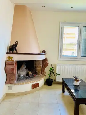 a living room with a fireplace and a table at Mersini Apartment in Chania Town