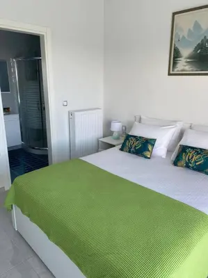 a bedroom with a large bed with a green blanket at Villa Panorama Modi, with pool and stunning views in Chania Town