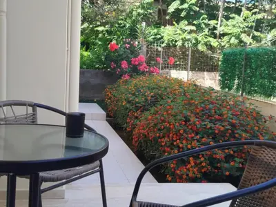 a patio with a table and chairs and flowers at Mel Studio 2 (kalamaki) in Kalamaki Chanion