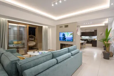 a living room with a blue couch and a kitchen at Overview Chania with sea view and amazing sunset in Chania Town