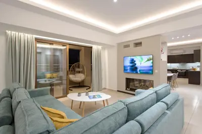 a living room with a blue couch and a tv at Overview Chania with sea view and amazing sunset in Chania Town