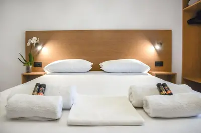 a bedroom with a large white bed with two pillows at SMAROULA in Elafonisi