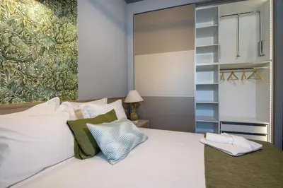 a bedroom with a white bed with a painting on the wall at Rena's luxury apartment with free private parking in Chania Town
