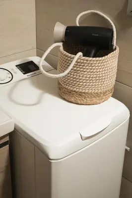 a phone in a basket sitting on top of a washing machine at ModernPastel Apartment - Private Parking,Near the Old Port in Chania Town