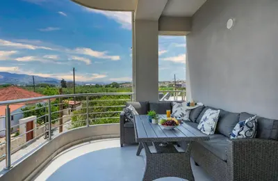 a patio with a couch and a table on a balcony at Fotini 's apartment near the city center. in Chania Town