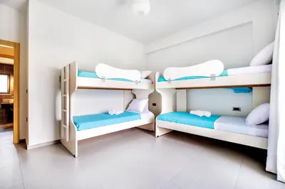 a room with three bunk beds in it at Fotini 's apartment near the city center. in Chania Town