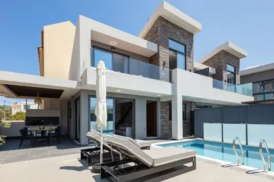 a villa with a swimming pool and a house at VillAgioi - Luxury villas, Private Pools, 450m to the Beach in Chania Town