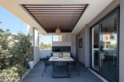 a dining room with a table and chairs on a patio at VillAgioi - Luxury villas, Private Pools, 450m to the Beach in Chania Town