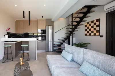 a living room with a couch and a kitchen at VillAgioi - Luxury villas, Private Pools, 450m to the Beach in Chania Town