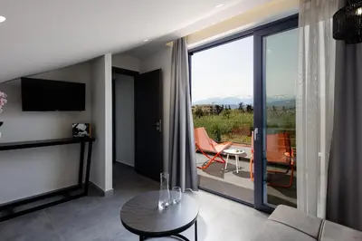 a living room with a couch and a balcony with a view at VillAgioi - Luxury villas, Private Pools, 450m to the Beach in Chania Town