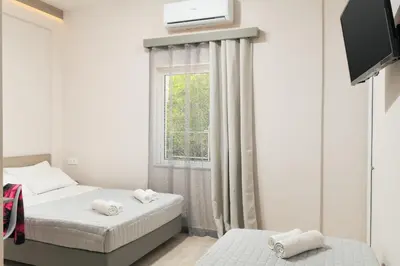 a bedroom with two beds and a window at Stefanie Studios in Agia Marina Nea Kydonias