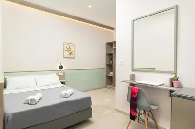 a bedroom with a bed and a desk with a laptop at Stefanie Studios in Agia Marina Nea Kydonias