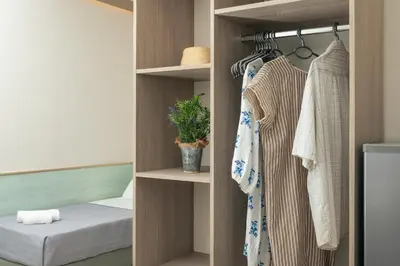 a room with a closet with a bed and clothes at Stefanie Studios in Agia Marina Nea Kydonias