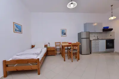 a kitchen with a bed and a table in a room at PALEOCHORA FINIKAS Apartments in Palaiochóra