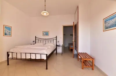 a bedroom with a bed and a bench in it at PALEOCHORA FINIKAS Apartments in Palaiochóra