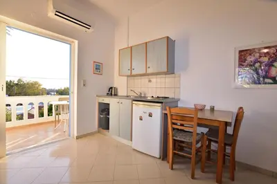 a kitchen with a table and a dining room at PALEOCHORA FINIKAS Apartments in Palaiochóra