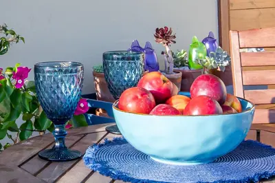 a bowl of apples on a table with two glasses at Maleme Yoga Blue in Chania Town