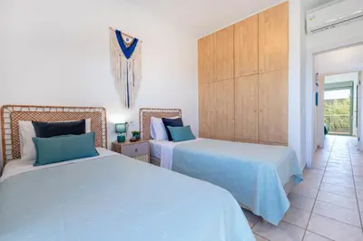 a bedroom with two beds and a hallway at Maleme Yoga Blue in Chania Town