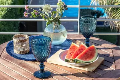 a table with two glasses and a plate of watermelon at Maleme Yoga Blue in Chania Town