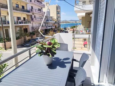 a balcony with a table and chairs and a potted plant at Sea Side View Home steps from the beach & city in Chania Town