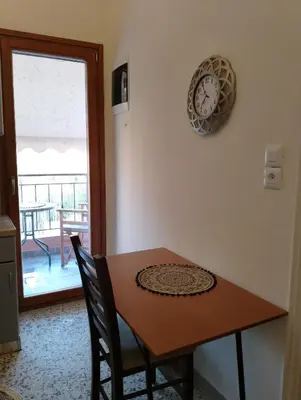 a dining room table with a clock on the wall at Domus Nicola in Chania Town