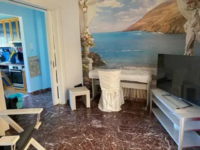 a living room with a tv and a painting of the ocean at At the Beach! +10min= port&center. in Chania Town