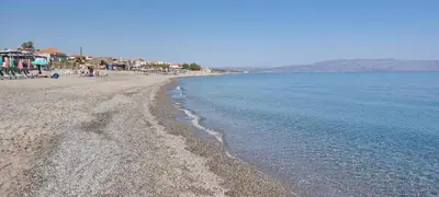 a beach with a group of people and the water at Fifi's luxury apartment in Plataniás