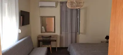 a bedroom with a bed and a desk and a mirror at Fifi's luxury apartment in Plataniás