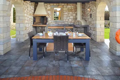 a blue table with chairs on a patio at Beachfront villa Aqua Marine with private pool,ping-pong & BBQ in Chania Town