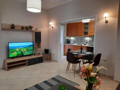 a living room with a television and a dining room at Pavlos Apartment in Chania Town