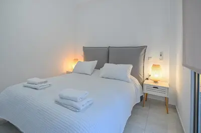 a bedroom with a white bed with towels on it at Moka Apartments in Chania Town