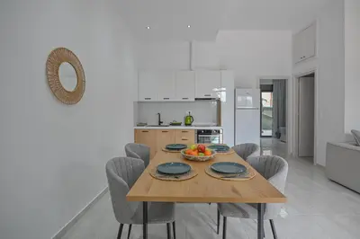 a kitchen and dining room with a wooden table and chairs at Moka Apartments in Chania Town