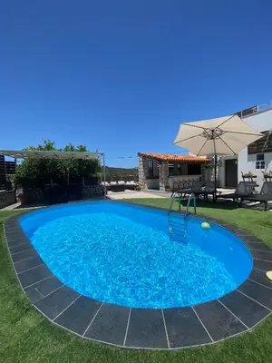 a large blue swimming pool with an umbrella at Casa Christina-Luxury Villa in Kissamos