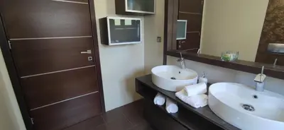 a bathroom with a white sink and a mirror at Bay Overlook Villa in Korakiaí