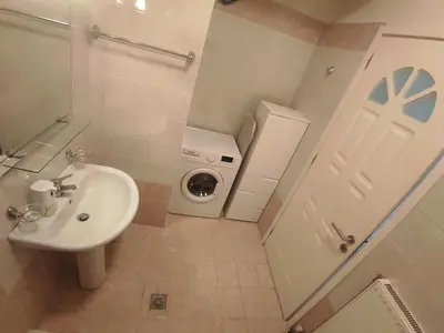 a bathroom with a sink and a washing machine at NickTheGreekApartment in Galatás