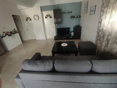 a living room with a couch and a table at NickTheGreekApartment in Galatás