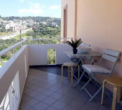 a balcony with a table and chairs and a view at Premium, 2-bedroom Apartment! in Chania Town