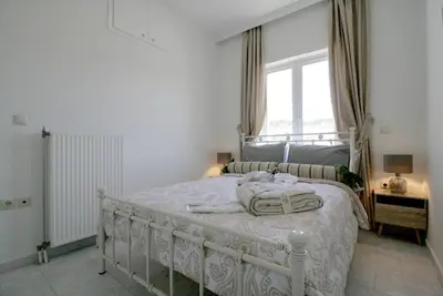 a white bed in a bedroom with a window at Premium, 2-bedroom Apartment! in Chania Town