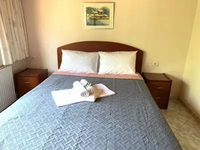 a bedroom with a bed with a cross and towels at VILLA FATIMA in Vryses