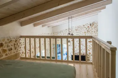 a room with a bed and a wooden railing at Casa Athelia: Traditional Home, Local Neighborhood in Chania Town