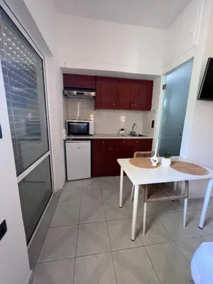 a small kitchen with a white table and a table at Electra Studios in Palaiochóra