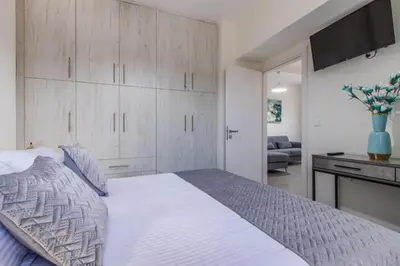 a bedroom with a large white bed and a desk at Luxury Katsoulakis Apartments in countryside in Alikianós