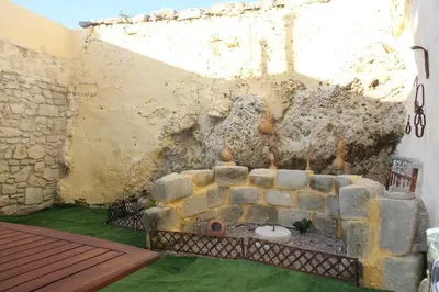 a living room with a stone fireplace in a wall at Aloni Studio in Azoyirás