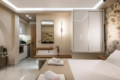 a bedroom with a large white bed and a kitchen at La vista de Pablo in Chania Town