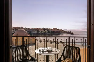 a table and chairs on a balcony with a view of the ocean at La vista de Pablo in Chania Town