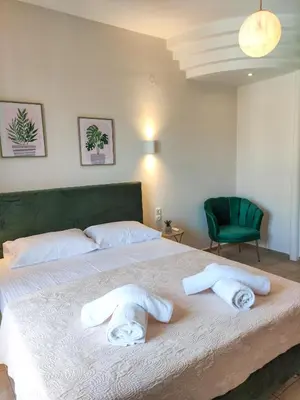 a bedroom with a large bed with towels on it at Rastoni Chania - Guests Apartment in Chania Town