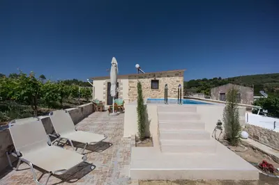 a villa with a swimming pool and two chairs at Villa Margarita's farm, private pool in Maláthiros