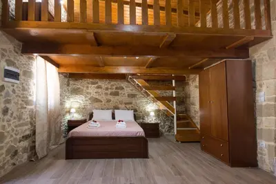 a bedroom with a bed and a wooden staircase at Villa Margarita's farm, private pool in Maláthiros