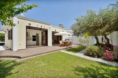a house with a wooden deck and a yard at Chania Boutique Villa - steps from the beach in Chania Town