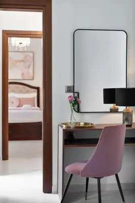 a bedroom with a desk and a pink chair at Chania Boutique Villa - steps from the beach in Chania Town